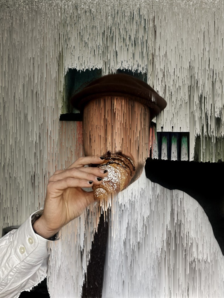 A person holding a croissant, partially obscured, with an artistic distorted background and wearing a hat and a white shirt.